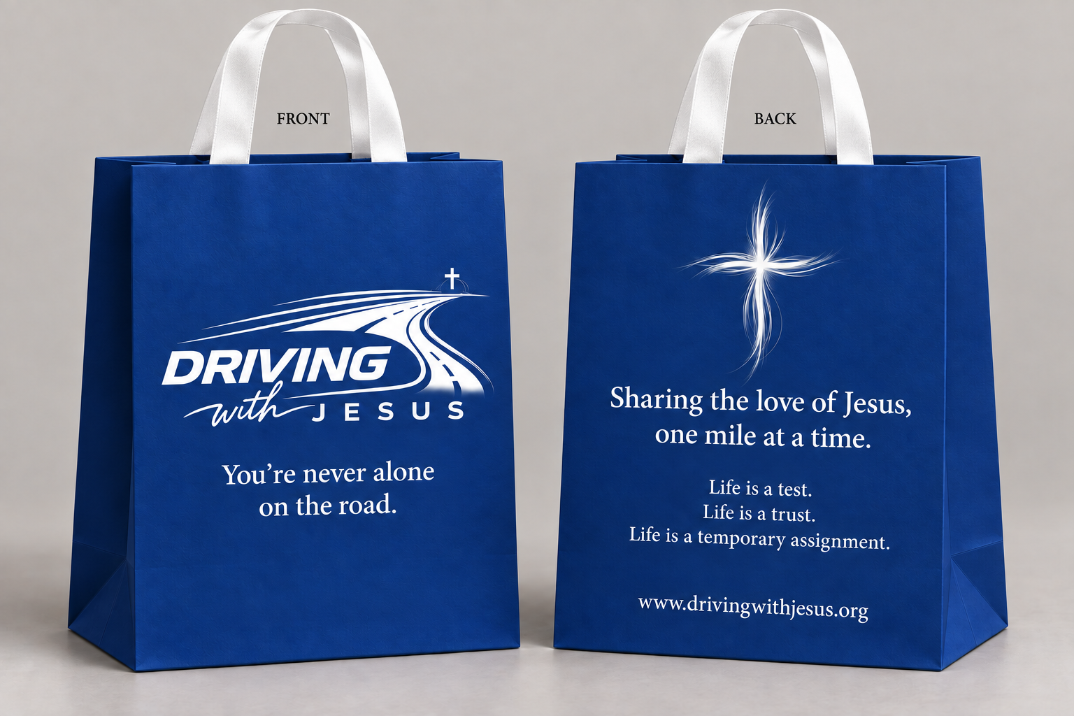Front and back of the new royal blue Driving With Jesus care bag, printed with the road to the cross and the words Sharing the love of Jesus, one mile at a time